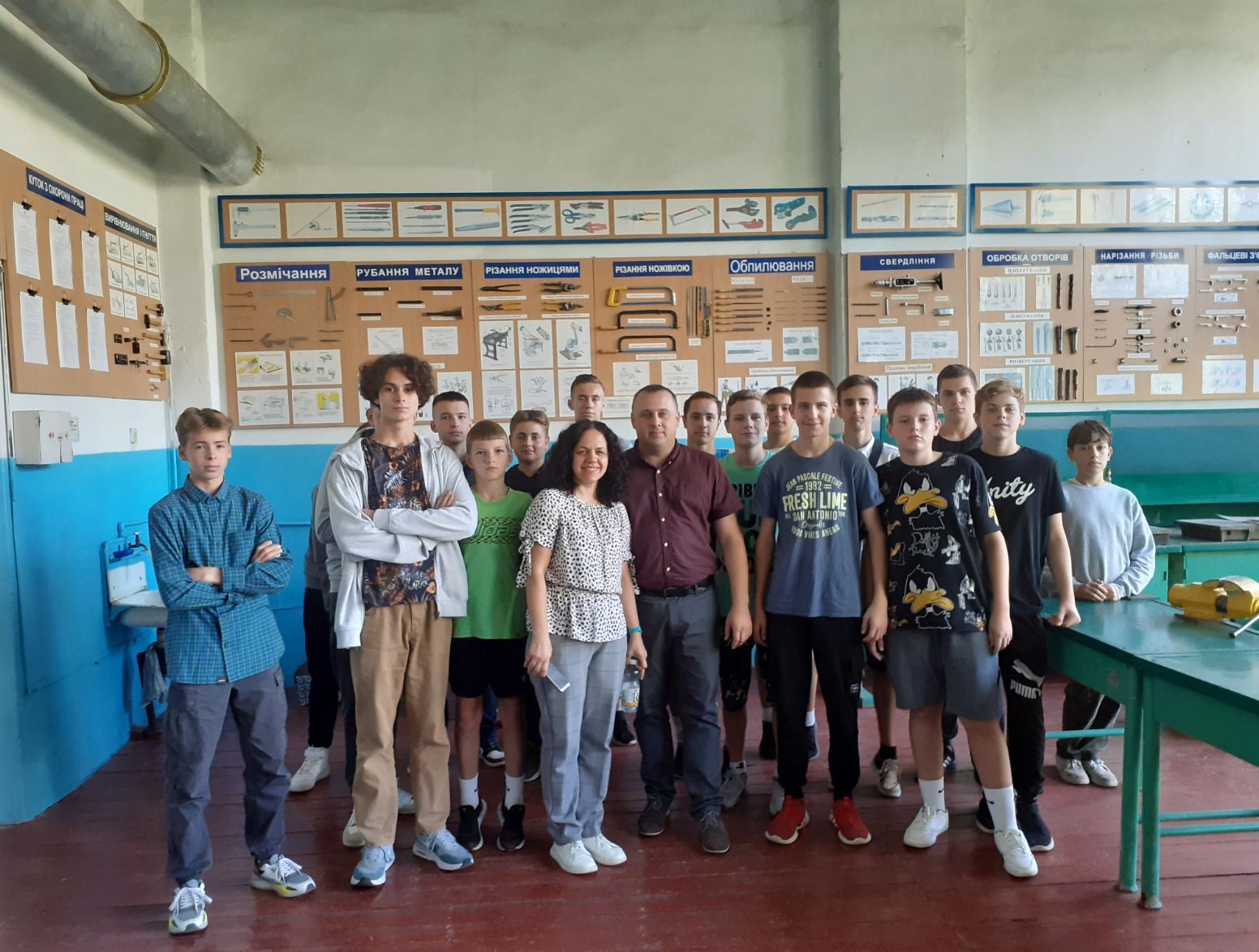 учні, вчителька технологій Тетяна Маланчук із  завідувачем кафедри сфери обслуговування, технологій та охорони праці Тарасом Сорокою в лабораторії з обробки конструкційних  матеріалів